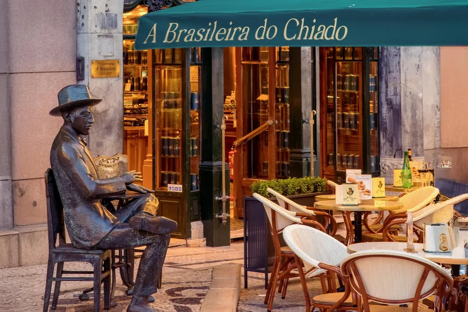 An old café terrace with a bronze statue in Lisbon